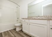 Thumbnail 47 of 75 - A white toilet sits in a bathroom next to a bathtub.
