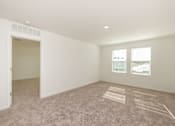 Thumbnail 42 of 75 - A large empty room with a carpet on the floor and a window showing a view of the outside.