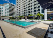 Thumbnail 3 of 19 - Miami FL Apartments - MB Station - Large Sparkling Pool Surrounded by Lounge Seating