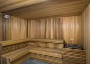 Thumbnail 11 of 19 - Apartments for Rent in Miami, FL - MB Station - Cozy Sauna with Wooden Seating, Walls, Ceiling, and Grey Tiled Floor.