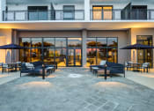 Thumbnail 8 of 19 - Apartments In Miami For Rent - MB Station - Community Outdoor Lounge Area With Plush Couches, Pillows, Patio Sets With Chairs