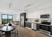 Thumbnail 1 of 30 - Modern apartment kitchen at MB Station featuring white cabinetry, quartz countertops, stainless steel appliances, and an open-concept layout in Coral Way, Miami.