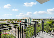 Thumbnail 13 of 30 - Private apartment balcony at MB Station overlooking Coral Way with expansive city skyline views near Brickell and Downtown Miami.