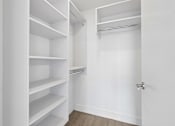 Thumbnail 9 of 30 - Large walk-in closet with built-in shelving at MB Station apartments in Miami, offering generous storage and organized living space.