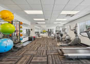 Thumbnail 3 of 14 - Pet-Friendly Townhomes in Burnsville, MN – Summit Townhomes - a fitness center with treadmills and other exercise equipment
