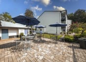 Thumbnail 20 of 27 - a patio with tables and chairs and umbrellas in front of a house