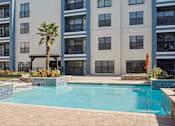 Thumbnail 13 of 22 - 1, 2 -Bedroom Apartments for Rent in North Little Rock, AR – Metropolitan– A pool in front of a building with a palm tree.