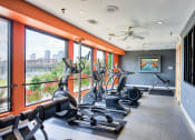 Thumbnail 3 of 22 - Apartments for Rent in North Little Rock, AR 72114– Metropolitan-   A fitness center with cardio equipment and glass windows in front of them