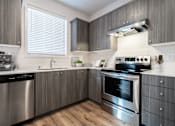 Thumbnail 1 of 22 - Vancouver, WA, Apartments Near Walnut Grove Park - Minnehaha Meadows - Kitchen with Vinyl Plank Flooring, Wood Cabinetry, Windows with Blinds, and Stainless Steel Appliances.