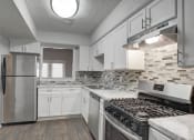Thumbnail 1 of 13 - Modern kitchen with stainless steel appliances and designer backsplash at Mirador at Idlewood in Clarkston, GA near Stone Mountain and East Atlanta