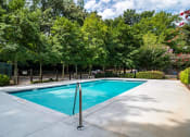 Thumbnail 2 of 13 - Sparkling outdoor swimming pool surrounded by trees at Mirador at Idlewood Apartments near Edgewood and Kirkwood