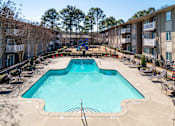 Thumbnail 2 of 24 - Swimming pool with lounge seating at Mirador at Peachtree Apartments near Briarcliff in Atlanta.