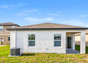 Thumbnail 6 of 75 - A white house with a brown roof and a grey door.