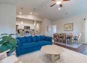 Thumbnail 4 of 22 - a living room with a blue couch and a dining room table