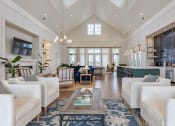Thumbnail 18 of 22 - a large living room with white couches and a coffee table