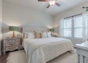 Thumbnail 6 of 22 - a bedroom with a large bed and a ceiling fan