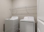 Thumbnail 7 of 22 - a washer and dryer in a laundry room with a rack on the wall
