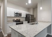 Thumbnail 9 of 22 - a kitchen with granite counter tops and a sink and a stove