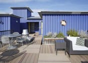 Thumbnail 5 of 28 - Apartments in Fremont, WA - Epicenter - Rooftop Deck with Outdoor Furniture and Potted Plants