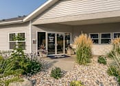 Thumbnail 16 of 17 - Apartments In Coeur d' Alene, ID, For Rent - Exterior View Of Leasing Office With Bushes And Greenery.
