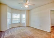Thumbnail 8 of 20 - Pet-Friendly Apartments in Beaumont, TX – Breakwater Bay - Living room with plush carpet, windows with coverings and ceiling fan.