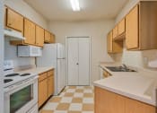 Thumbnail 1 of 20 - Beaumont, TX Apartments – Breakwater Bay - Kitchen with tile flooring, stainless steel sink, plenty of cabinets for storage, oven/stove top, fridge, and pantry