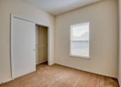 Thumbnail 9 of 20 - Apartments In Beaumont, TX for Rent – Breakwater Bay - Bedroom with plush carpet, closet for storage, and window with coverings
