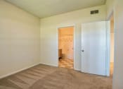 Thumbnail 10 of 20 - Beaumont, TX Apartments – Breakwater Bay - Bedroom with plush carpet, window with coverings and door to private bathroom