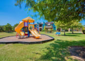 Thumbnail 15 of 24 - A playground at Lake Forest surrounded by grass