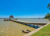 Thumbnail 17 of 24 - A grassy field with a dock that leads above the water on a bridge to a covering