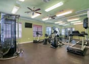 Thumbnail 3 of 24 - A gym with ceiling fans and cardio equipment and lifting equipment 