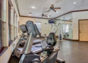 Thumbnail 17 of 25 - Gym with fitness and cardio equipment with a ceiling fan and windows
