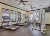 Thumbnail 3 of 25 - Gym with fitness and cardio equipment with a ceiling fan and windows
