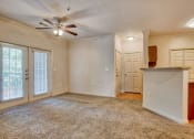 Thumbnail 7 of 25 - Living room with carpet, ceiling fan, glass doors and walkway