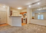 Thumbnail 6 of 25 - Living room with carpet and kitchen in background with wood floor