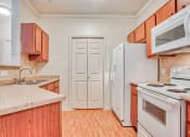 Thumbnail 4 of 25 - Kitchen with a sink, pantry door, white fridge, white stove top/oven, white microwave and wood cabinets with a marble countertop