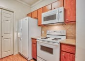 Thumbnail 5 of 25 - Kitchen with a sink, pantry door, white fridge, white stove top/oven, white microwave and wood cabinets with a marble countertop