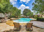 Thumbnail 13 of 25 - Mission oaks pool surrounded by trees and beach chairs