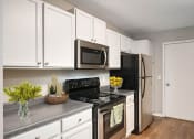 Thumbnail 1 of 14 - Burnsville, MN Townhomes – Summit Townhomes - modern kitchen with white cabinets and stainless steel appliances