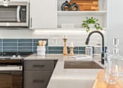Thumbnail 63 of 78 - A modern kitchen with a stainless steel microwave and a wooden cutting board.
