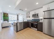 Thumbnail 1 of 78 - A modern kitchen with stainless steel appliances and wooden flooring.