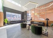 Thumbnail 2 of 78 - A modern waiting area with a large window and comfortable seating.