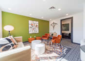 Thumbnail 11 of 78 - A living room with a white couch, orange chairs, and a rug.
