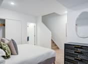 Thumbnail 59 of 78 - a bedroom with a large bed and a mirror on the wall