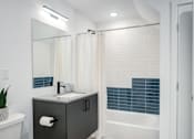 Thumbnail 51 of 78 - a bathroom with a sink and a shower and a mirror