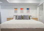 Thumbnail 42 of 78 - a bedroom with a large bed and three paintings on the wall