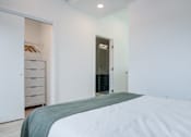 Thumbnail 58 of 78 - a white bedroom with a large bed and a closet
