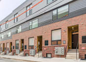 Thumbnail 39 of 78 - the side of a brick apartment building with stairs and a sidewalk