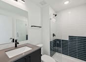 Thumbnail 55 of 78 - A modern bathroom with a sink, mirror, toilet, and shower.