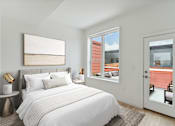 Thumbnail 70 of 78 - Compact bedroom with a comfortable bed with navy and white bedding, plush pillows, a white fluffy rug, and a plant by the window, creating a serene and inviting atmosphere.
